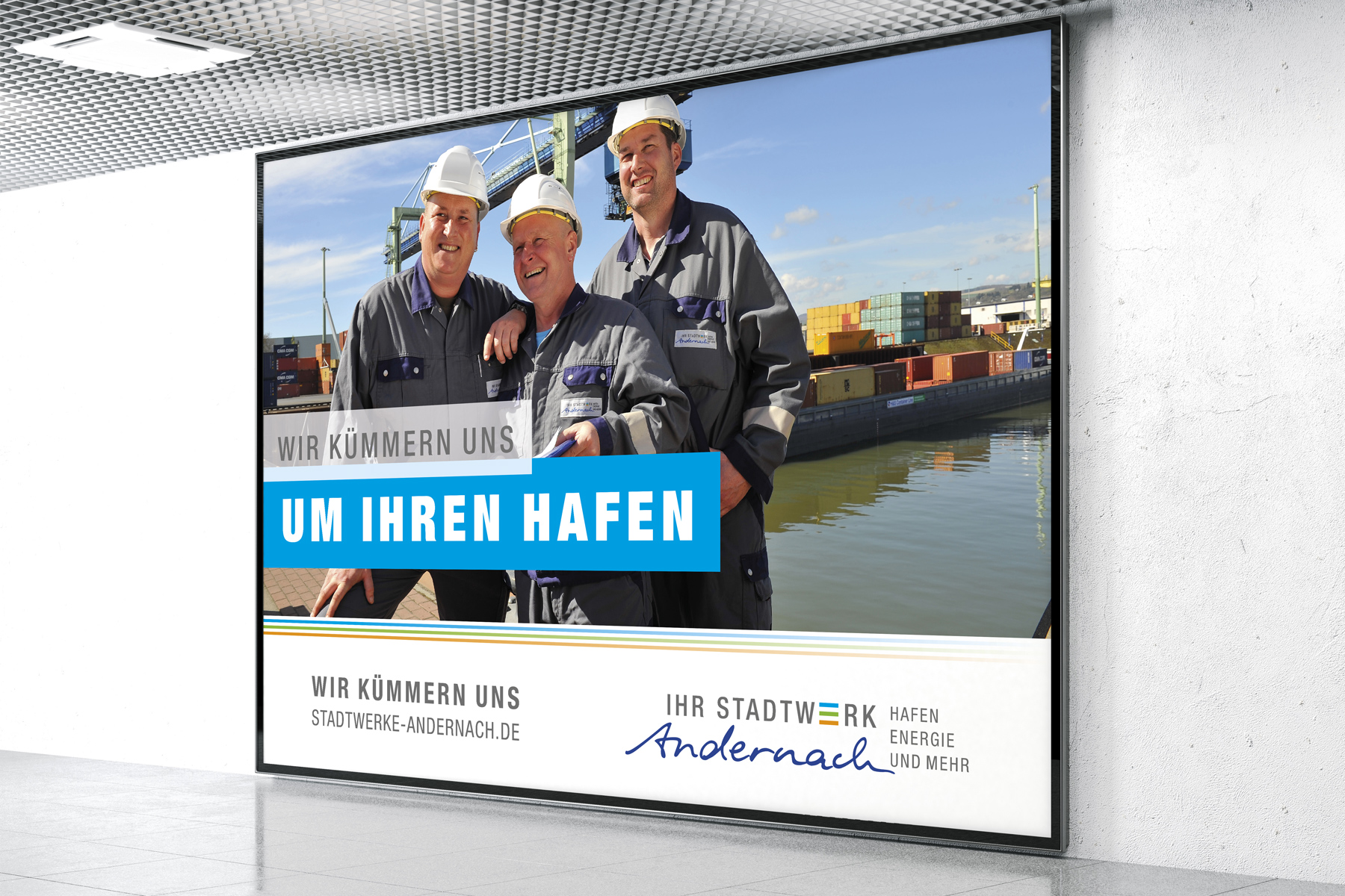 Drei Arbeiter in Uniformen stehen lächelnd vor Schiffscontainern in einem Hafen.