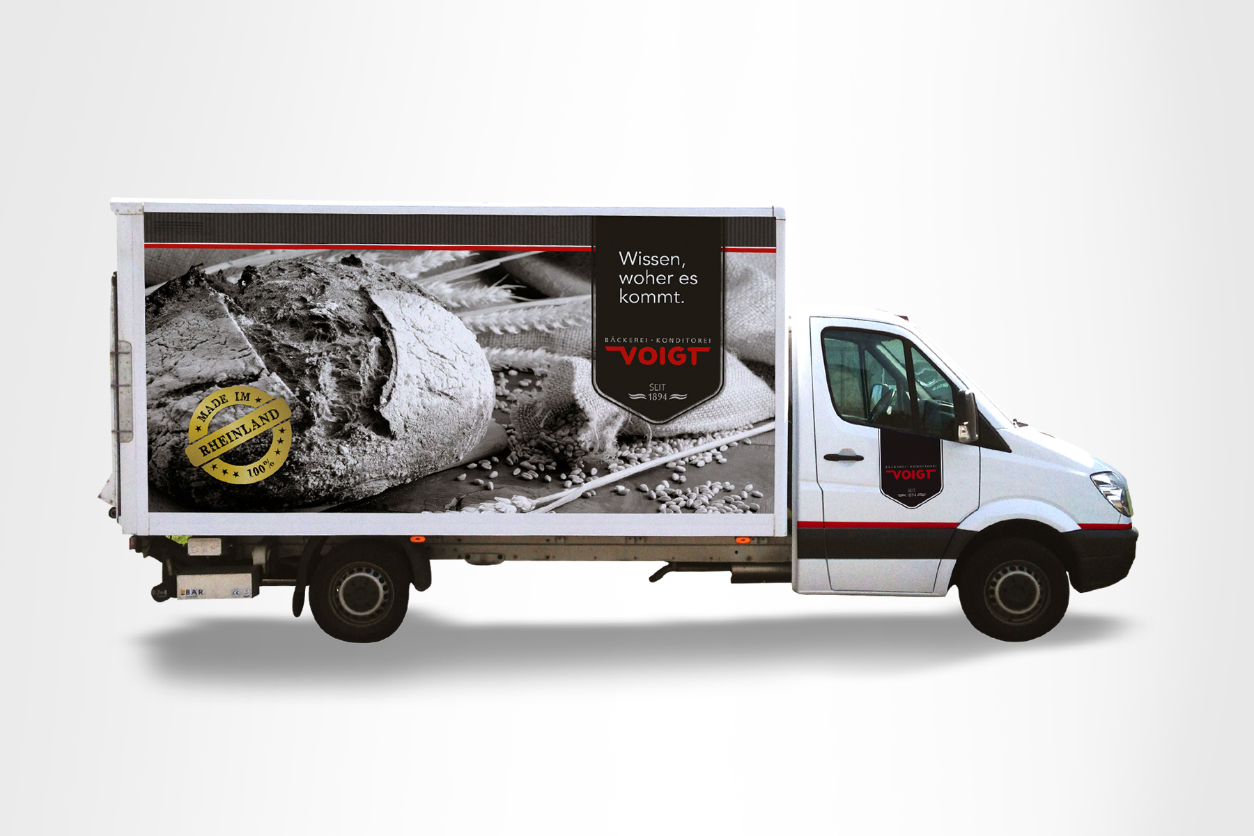 Weißer Lieferwagen mit Bäckereiwerbung mit Brot und deutschem Text auf der Seitenwand.